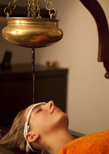 A guest relaxing during a Shirodhara treatment